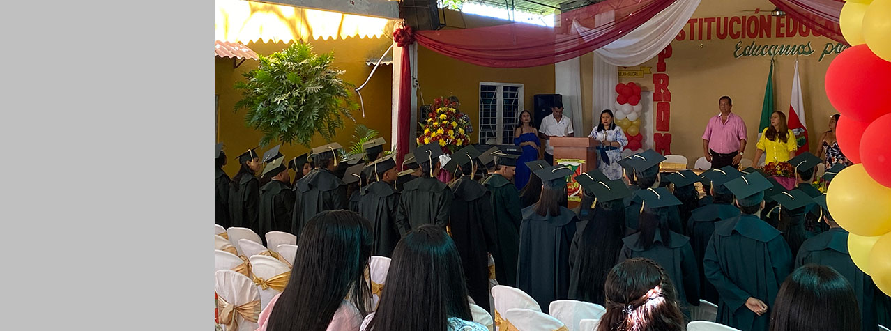 Foto desde la parte de atrás de un espacio donde se lleva acabo una graduación