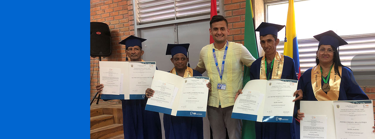Foto de maestro con 4 graduandos mostrando su diploma 