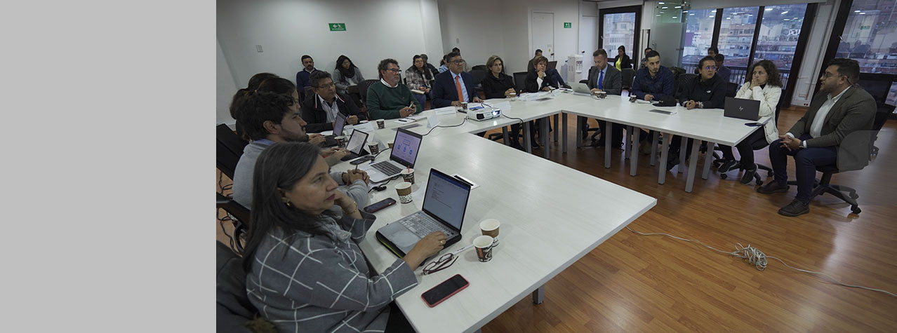 Foto de reunión de integrantes del CNR en unas mesas en forma de U  hombres y mujeres hablando