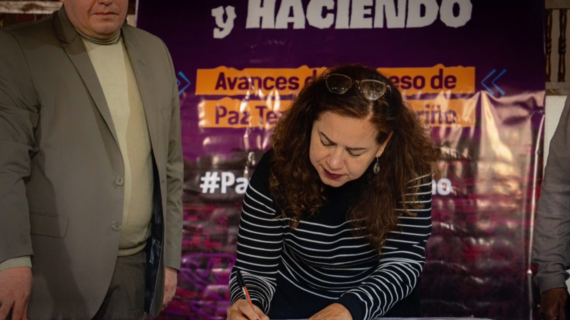directora de ARN firmando documento