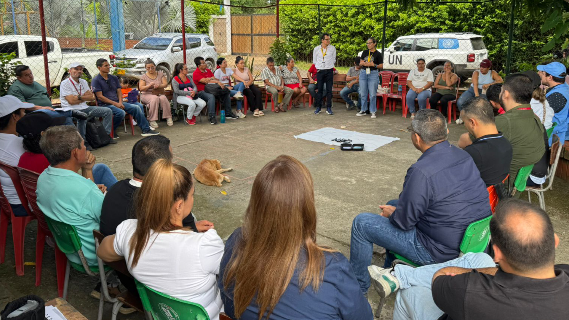 personas reunidas en una cancha escuchando charla