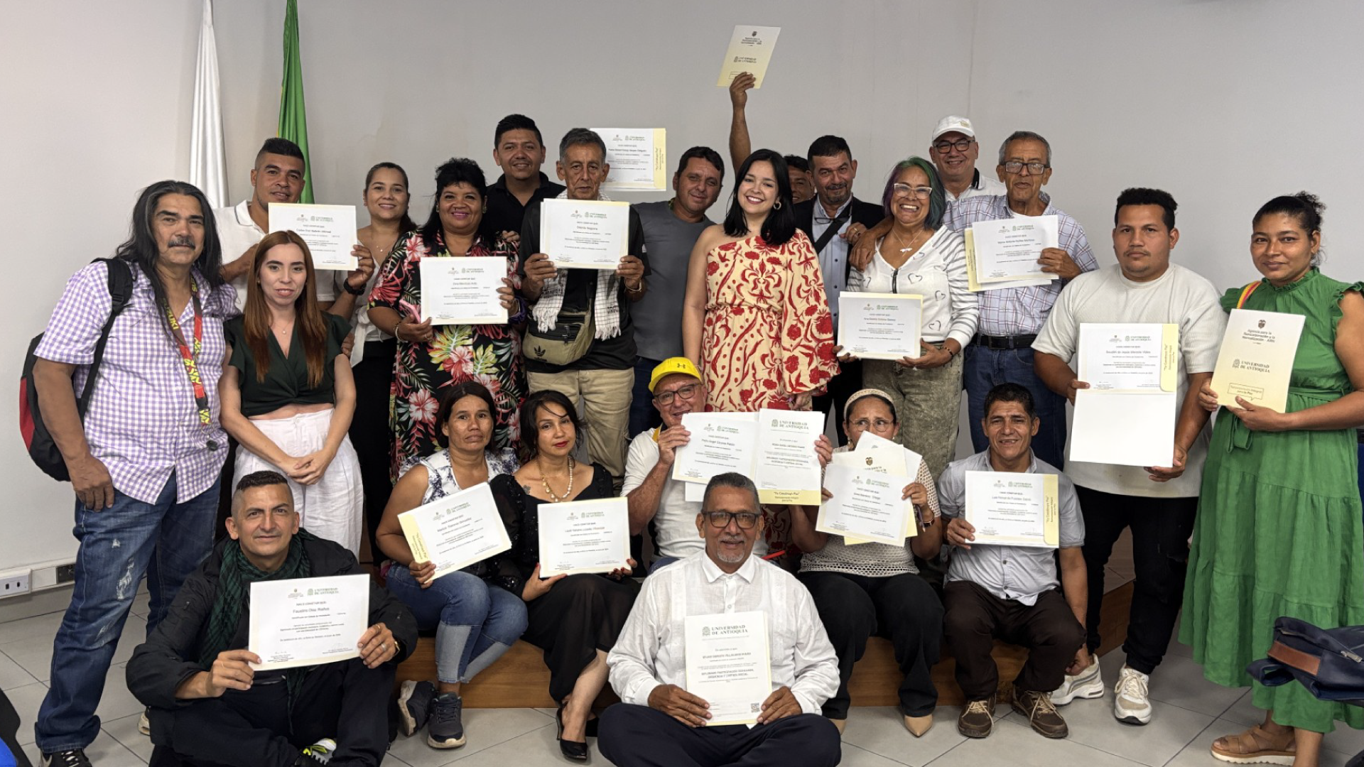 personas posando con diploma de graduación