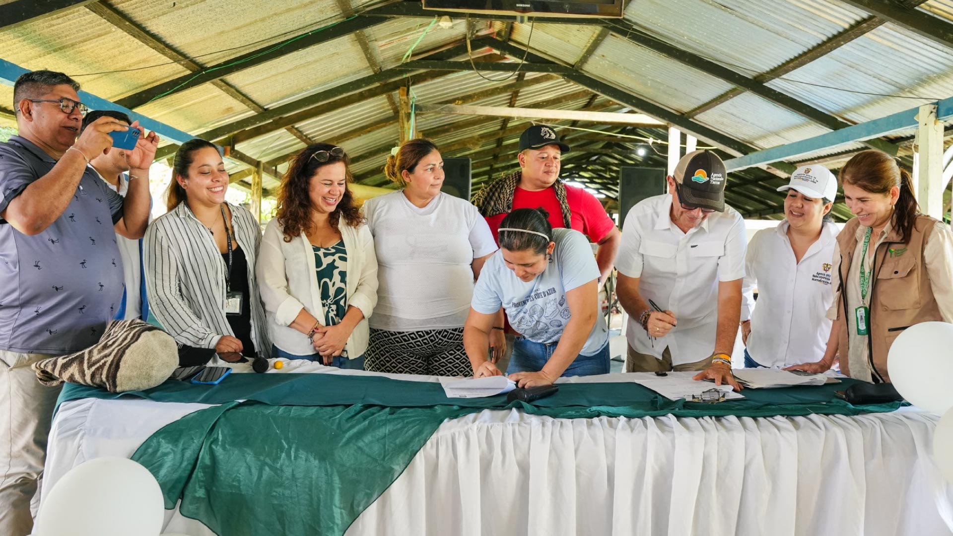 personas firmando acuerdo