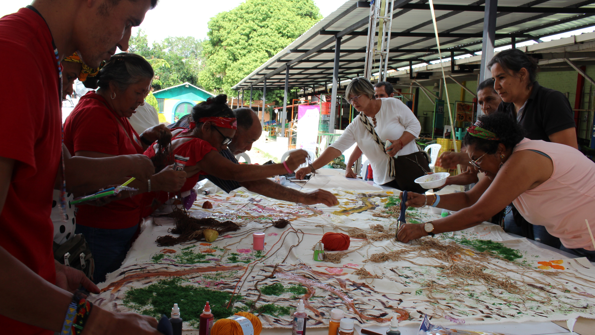 personas decorando una sabana con lana y pinturas