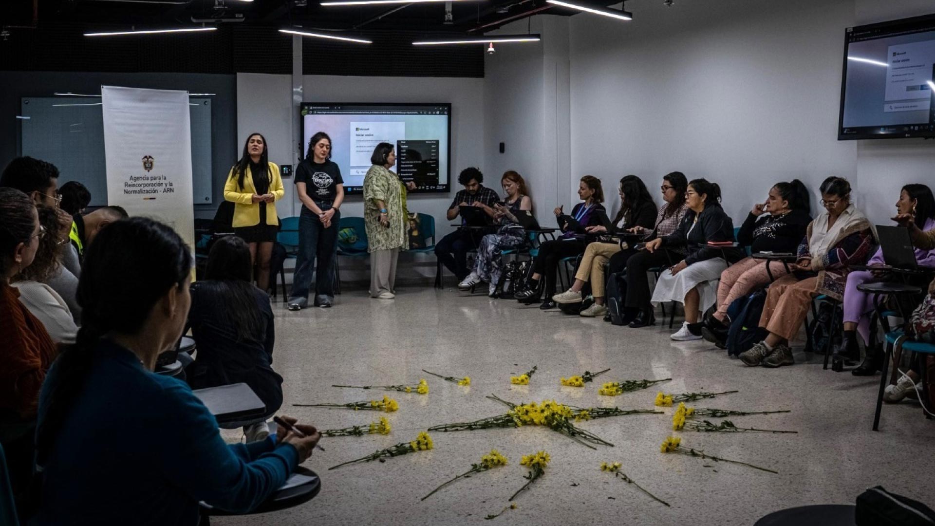 personas reunidas al rededor de circulo de flores