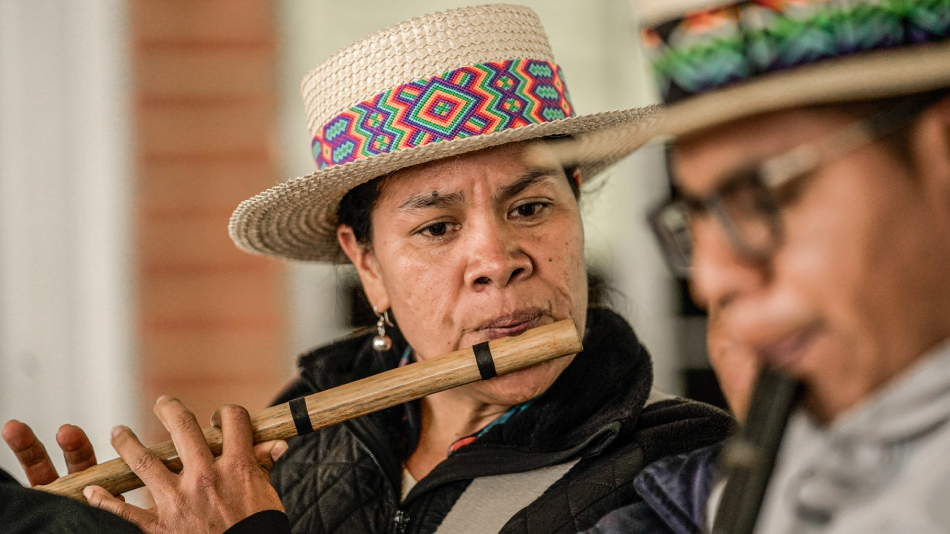 mujer tocando flauta indigena