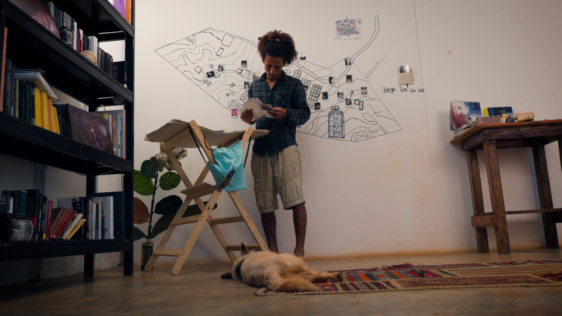 hombre leyendo notas con un perro en sus pies
