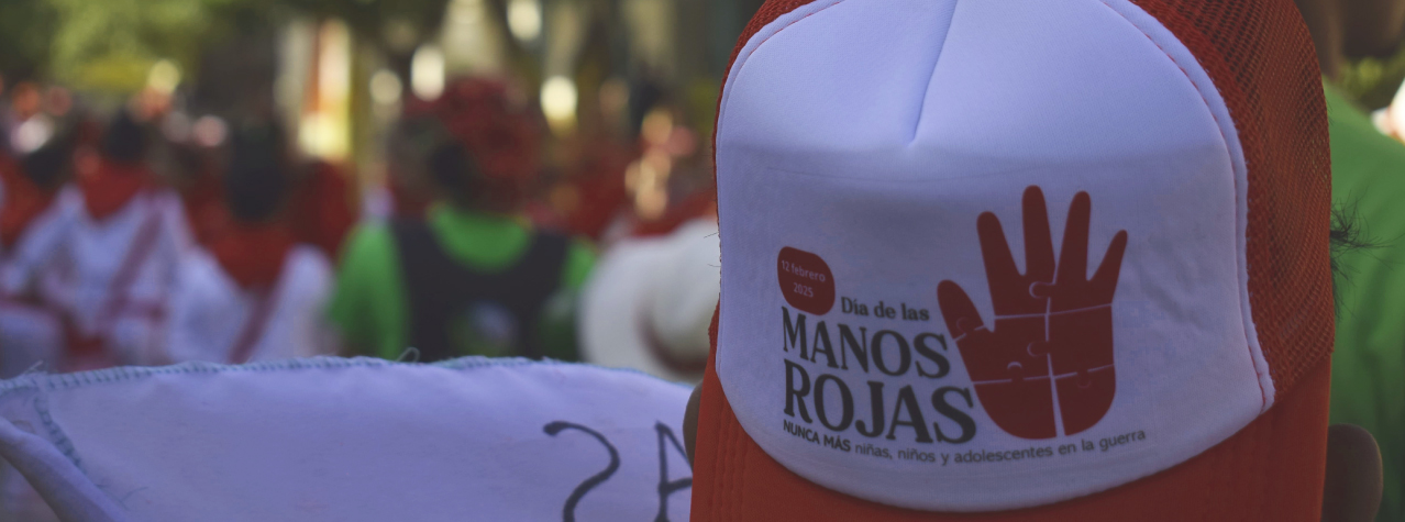 Una gorra con un mensaje de Día de las Manos Rojas. Nunca más niñas, niños y asolescentes en la guerra.