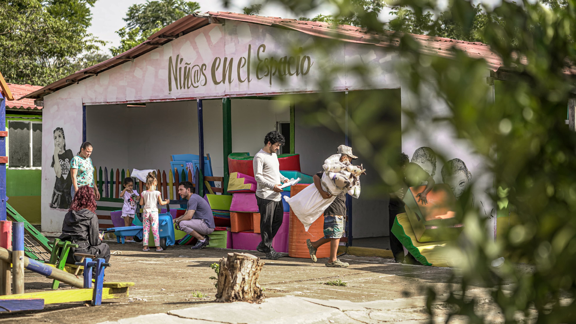 personas caminando enfrente de una casa que dice niños en el espacio