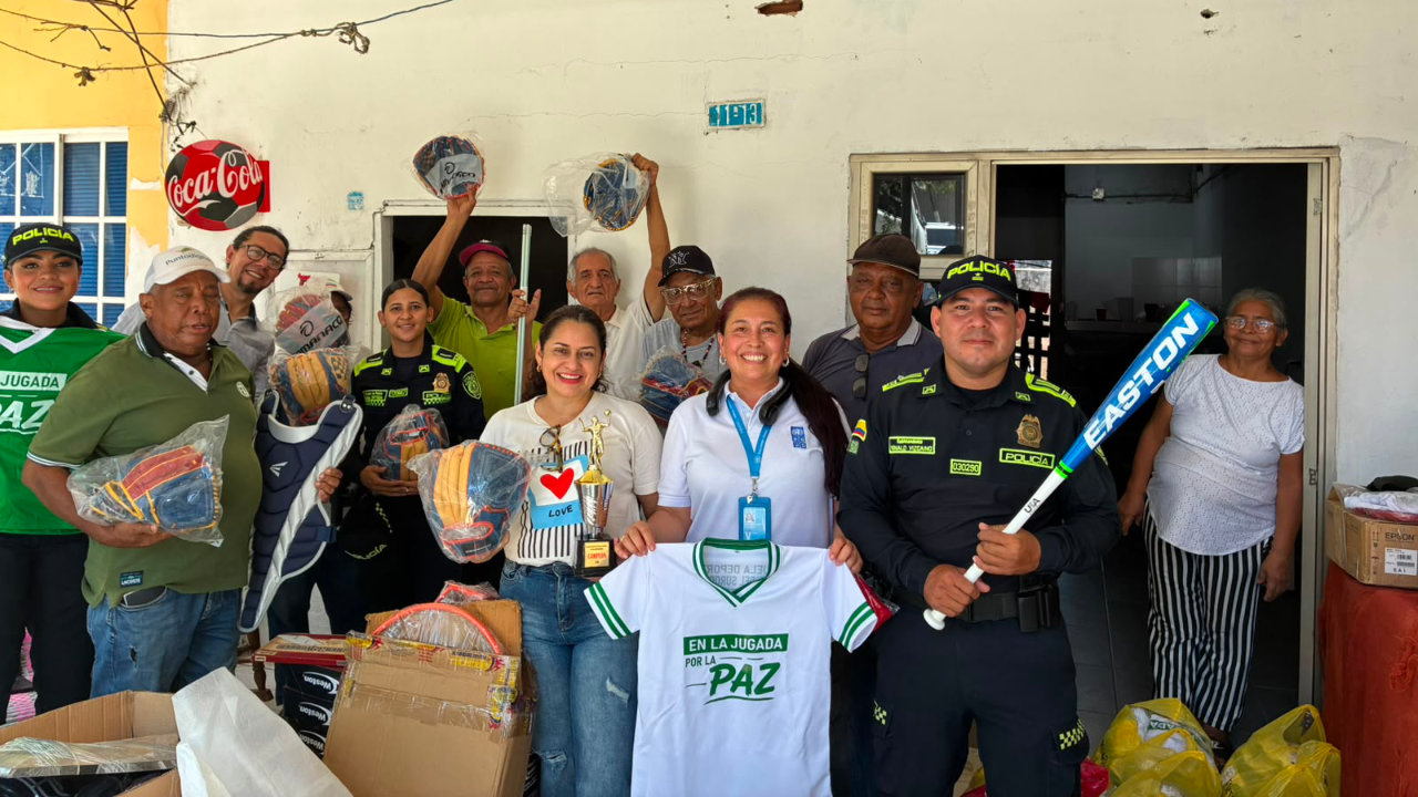 Integrantes de la Policía Nacional, funcionarios y miembros de la comunidad posan con implementos deportivos
