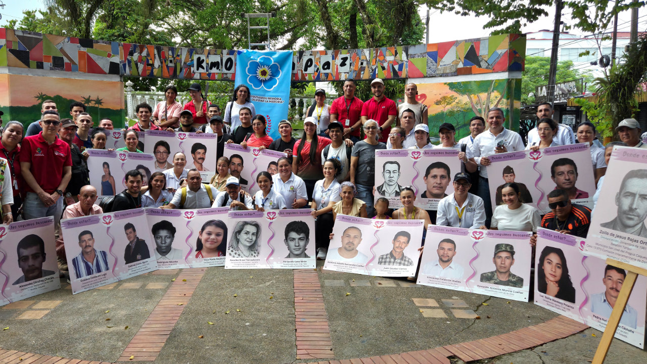 Firmantes de paz, comunidades e instituciones participan en un acto de memoria con retratos de personas desaparecidas en Caquetá