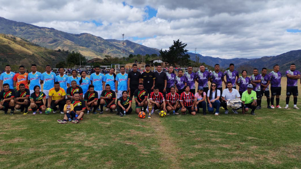 Firmantes de paz y comunidad de Jambaló, Cauca, en fotografía grupal durante jornada deportiva por la paz y la reconciliación